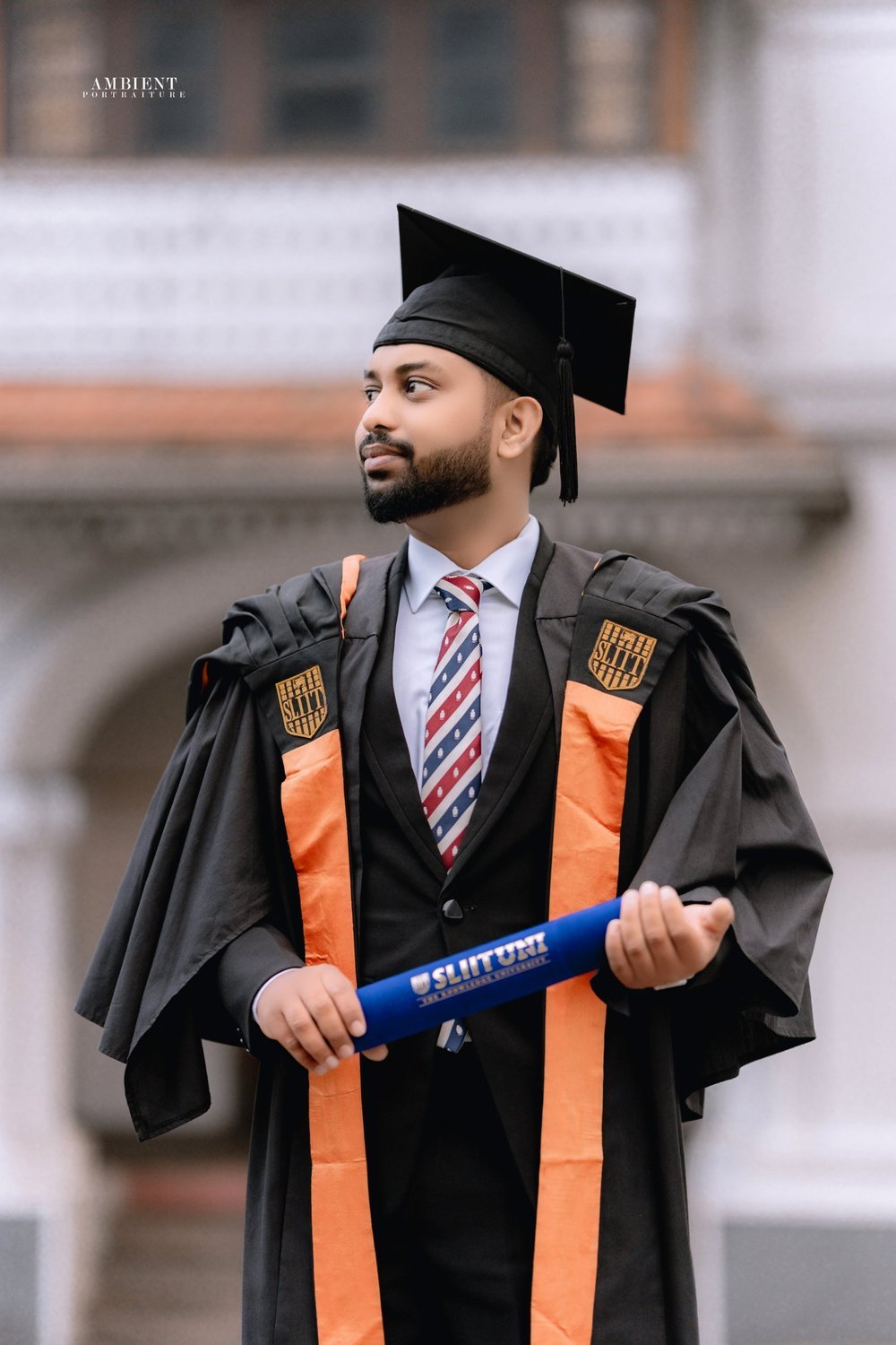 Chanodya Weerasinghe in graduation robes holding a SLIIT scroll
